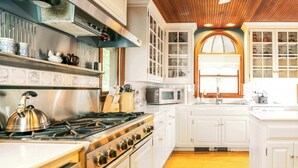 Una cocina con armarios blancos, una estufa y un microondas.