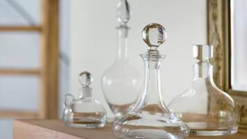 Tres botellas de cristal sobre una estantería de madera.