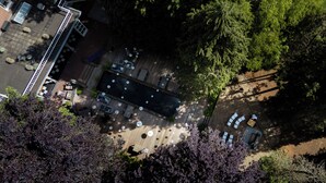 An aerial view of a courtyard with outdoor seating, a pool, and surrounding trees. - Villa Polder – Boutique Hotel near Eindhoven (Gemert)