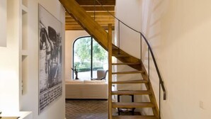 A wooden staircase with a view of a living room and a window. - Villa Polder – Boutique Hotel near Eindhoven (Gemert)