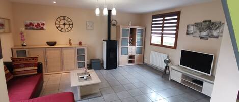 Un salon avec un canapé, un téléviseur et une cheminée.