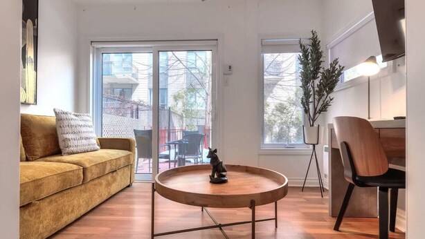 Een moderne woonkamer met een bank, een ronde salontafel en een fauteuil.