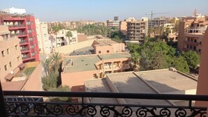 Zona residencial con edificios de varios pisos, algunos con balcones, y cielo despejado.