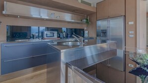 Una cocina moderna con electrodomésticos de acero inoxidable, un lavamanos grande y una ventana con vistas panorámicas.