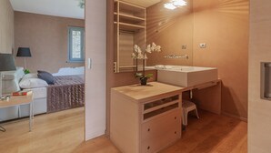 Un baño moderno con un espejo grande, un lavamanos y una orquídea en maceta.