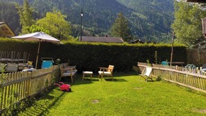 A backyard with a wooden fence, a lawn, and a view of mountains. - The cosy refuge (Chamonix-Mont-Blanc)