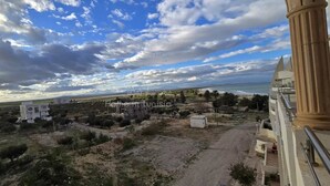 A coastal view with a road leading to a building complex.