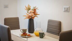 A dining table with two chairs, a vase with flowers, a glass pitcher, a mug, and a plate with toast and strawberries. - Vatican Domvs, 250 meters from the Vatican Museums (Roma)