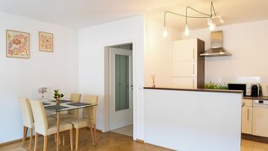 A modern kitchen with white cabinets, a stainless steel range hood, and a built-in microwave. - Cozy apartment+kitchen+Netflix (Essen)