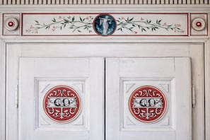 Una puerta blanca con dos medallones circulares, cada uno con un diseño rojo y blanco y un emblema central.