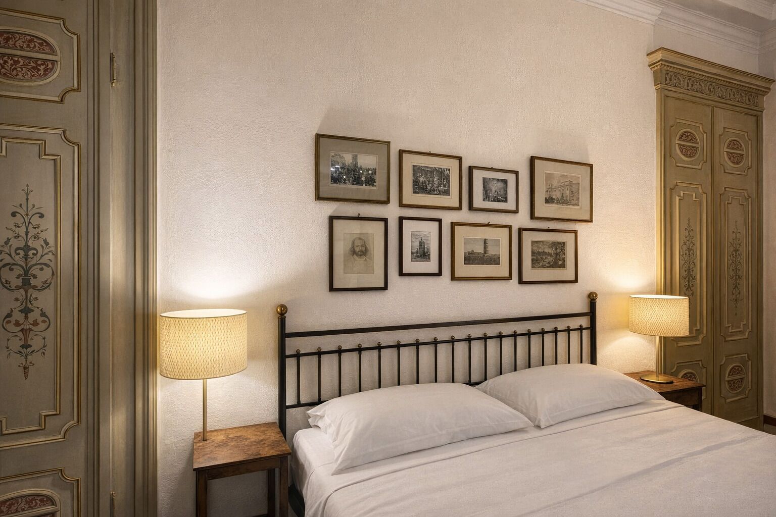 A neatly arranged bedroom with a bed, two bedside tables with lamps, and a wall adorned with framed pictures.