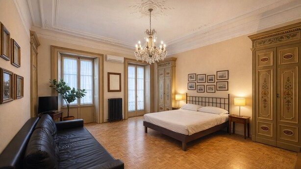 A spacious bedroom with a large bed, a sitting area with a sofa, a chandelier, and a view of the city. - dHomes -Apartments Rooms- Galleria Gold  (Milan)