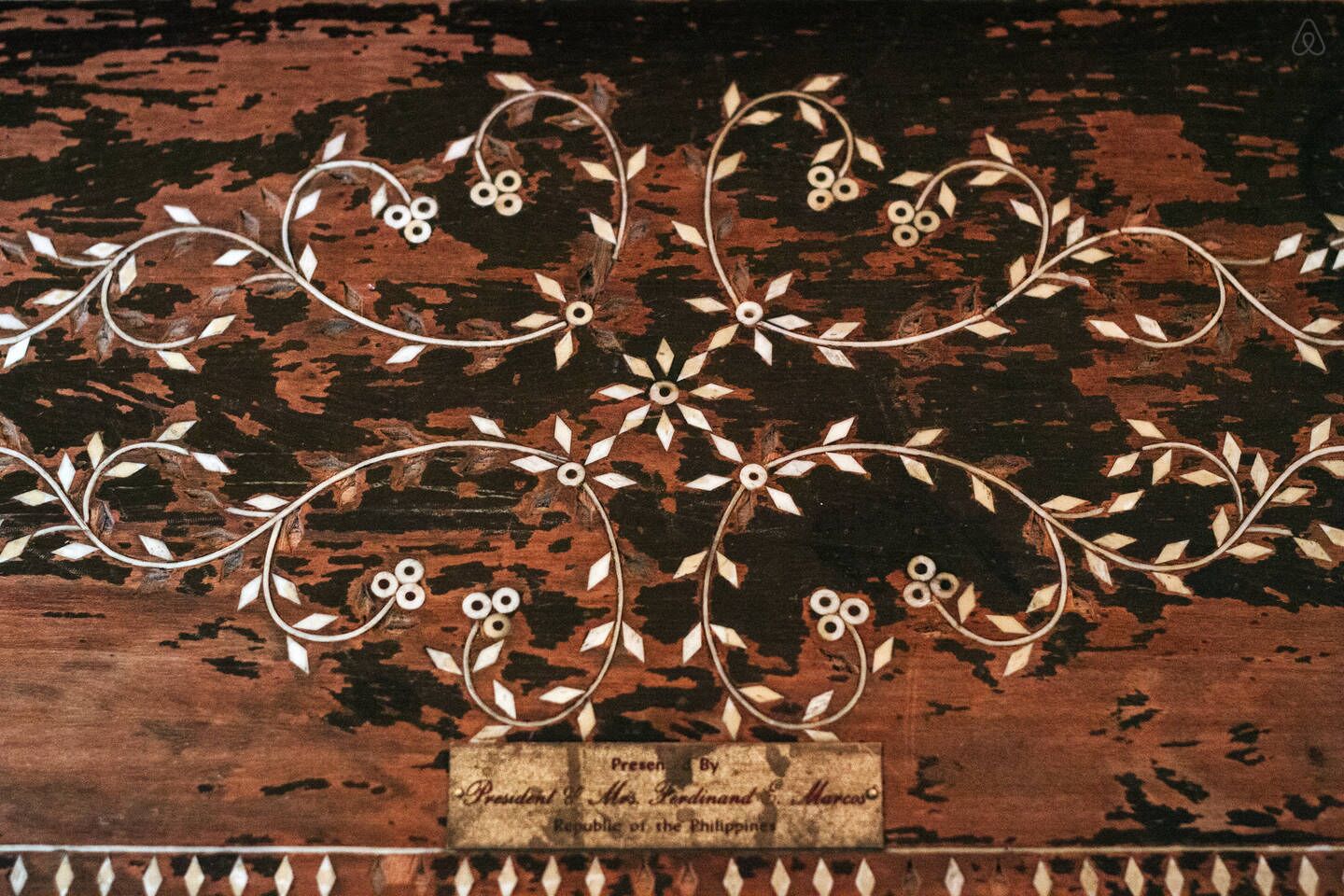 Une surface en bois ornée de motifs floraux et de motifs de vigne complexes.
