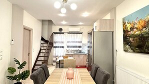 Eine moderne Küche mit Essbereich, einer Treppe und einem Gemälde an der Wand.