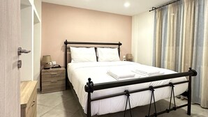 Ein Schlafzimmer mit Bett, Nachttischen, einem Kleiderschrank und einem Fenster mit Vorhängen.