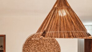 Lámpara colgante cónica de tejido con base circular también tejida.