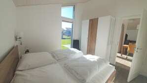 Een slaapkamer met een bed, een kledingkast en een raam.