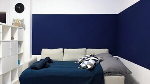 A bedroom with a bed, a white wardrobe, and a clock on the wall. - Modern 2-room apartment | 6 persons | WIFI (Unknown)