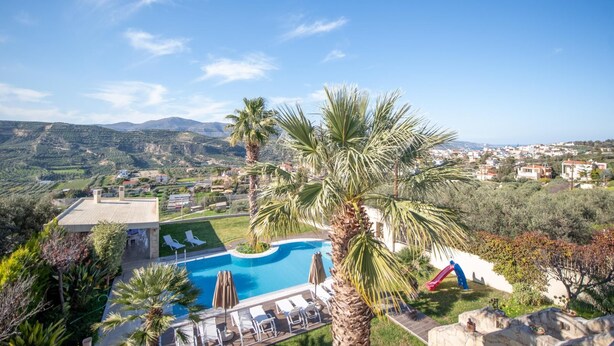 Un resort con piscina, palmeras y vistas del paisaje circundante.