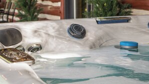 A hot tub with a wooden exterior wall and windows. - The Little Place on Pine (Harrison)