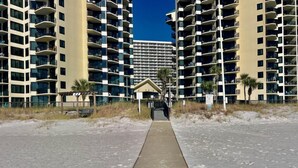 A pathway leading to a building with multiple balconies and a clear sky. - Sunbird 1BR/1BA, Direct Beachfront! Stunning Views! (Panama City Beach)