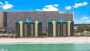 A beachfront hotel with multiple high-rise buildings, a sandy beach, and clear turquoise waters. - Sunbird 1BR/1BA, Direct Beachfront! Stunning Views! (Panama City Beach)