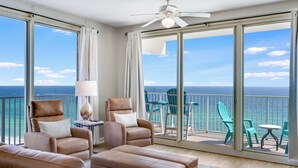 A spacious balcony with a view of the ocean, furnished with leather sofas and chairs, and a ceiling fan. - Direct Beachfront, wrap balcony, sleeps 10! Shores of Panama (Panama City Beach)