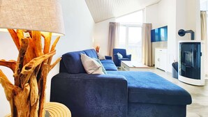 Una sala de estar moderna con un sofá, una lámpara y un televisor.