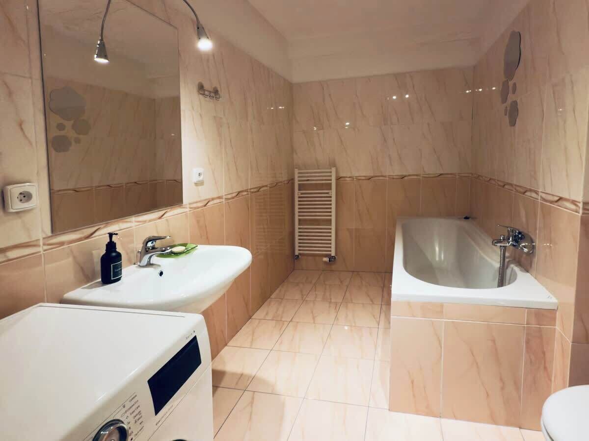A bathroom with two sinks, a bathtub, and a mirror.