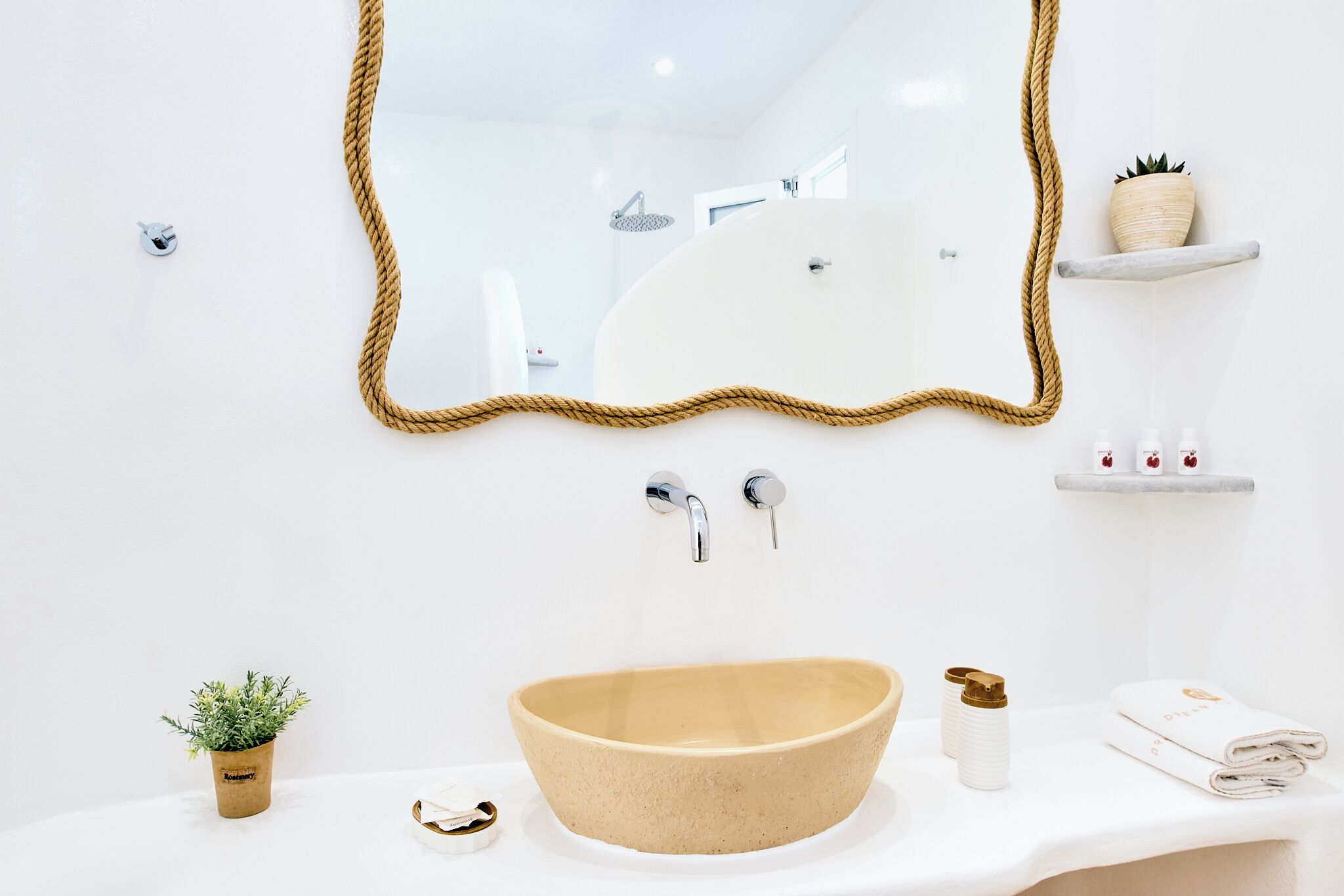 Ein modernes Badezimmer mit einem großen, beige farbenen Waschbecken, einem Spiegel mit Ropeschrank und einer kleinen Ablage für Toilettenartikel.
