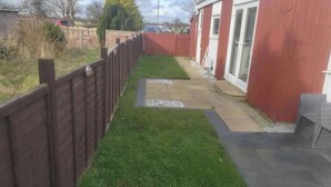 A narrow pathway leading to a red building with a gated entrance. - 1br-garden-parking-pets-10 Mins to Beach (Hornsea)