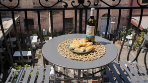 A round table with a bottle of wine and bread on a balcony. - POLPO ROOM With Private Bath City Centre| PVT PARK (Moneglia)