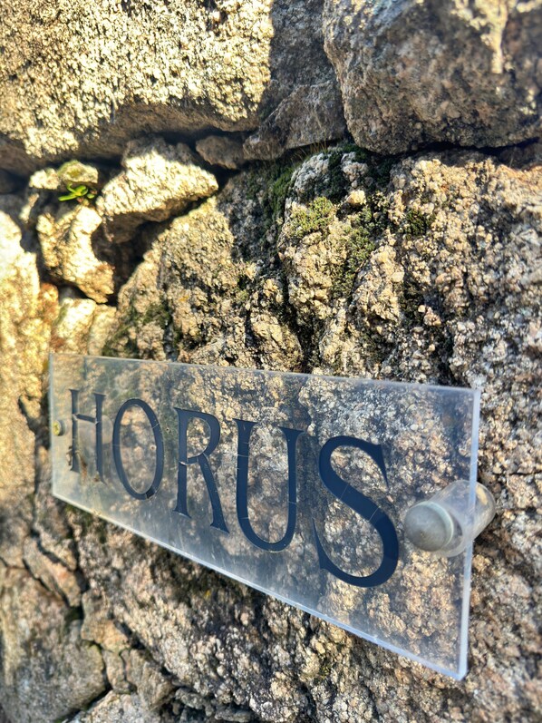 Un letrero con la palabra 'HORUS' colocada sobre una pared de piedra.