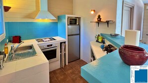 Una cocina compacta con lavabo, hornilla, horno y refrigerador.