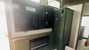 A compact RV interior with a kitchenette, a small seating area, and a window for natural light. - 4,000 sq.ft. Jeep Shop Man Cave with Luxury Trailer (Moab)