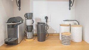 A kitchen with a coffee maker, a kettle, and storage containers on the counter.
