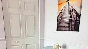 A room with a wooden floor, a white door, a light blue desk with drawers, and a framed picture of a pier on the wall. - The Lidiya Room, right on the famous Daytona Beach. (Daytona Beach)