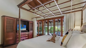 A hotel room with a large bed, wooden wardrobe, and a TV on a stand. - Two Luxury Villas in Cocotal for Large Groups – With Jacuzzi, Pools, Gym (Punta Cana)
