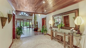 A spacious hallway with a wooden ceiling, a glass console table, and a large mirror. - Two Luxury Villas in Cocotal for Large Groups – With Jacuzzi, Pools, Gym (Punta Cana)