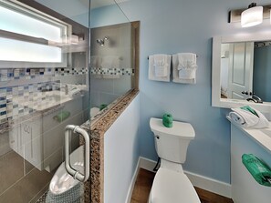 A bathroom with a glass shower enclosure, a toilet, and a sink. - Noon Wave | New Furnishings, Close to Beach, Bridge + Dining (Fort Myers Beach)
