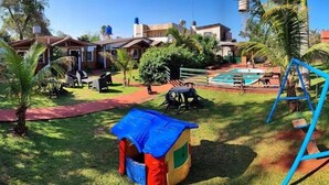 A residential area with a swimming pool, a swing set, and a small playhouse. - El Rosedal Cataratas / Apartment - 2 levels (Puerto Iguazú)
