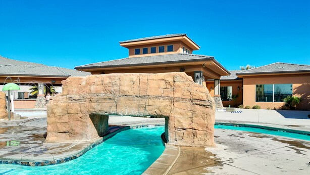 A swimming pool with a rock arch structure, clear blue water, and a no diving sign. - Stunning townhome with premiere resort amenities, lazy river and private hot tub (Hurricane)