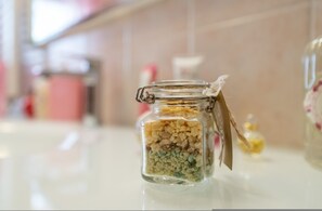 A glass jar with a metal clasp lid containing various items, placed on a reflective surface. - Grace s House in Pisa (Pisa)