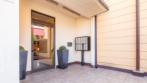 A building entrance with a glass door, a metal mailbox, and two potted plants. - Grace s House in Pisa (Pisa)