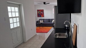 Eine moderne Küche mit schwarzem Arbeitsplatz, Spüle aus Edelstahl und Schneidebrett aus Holz.