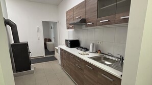 A modern kitchen with wooden cabinets, a stainless steel sink, and a built-in microwave.