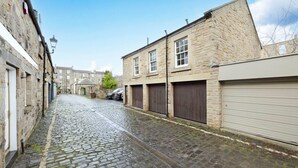 A cobblestone street lined with stone buildings, some with closed shutters. - Bright&Cosy Flat near Scottish Gallery (Edinburgh)