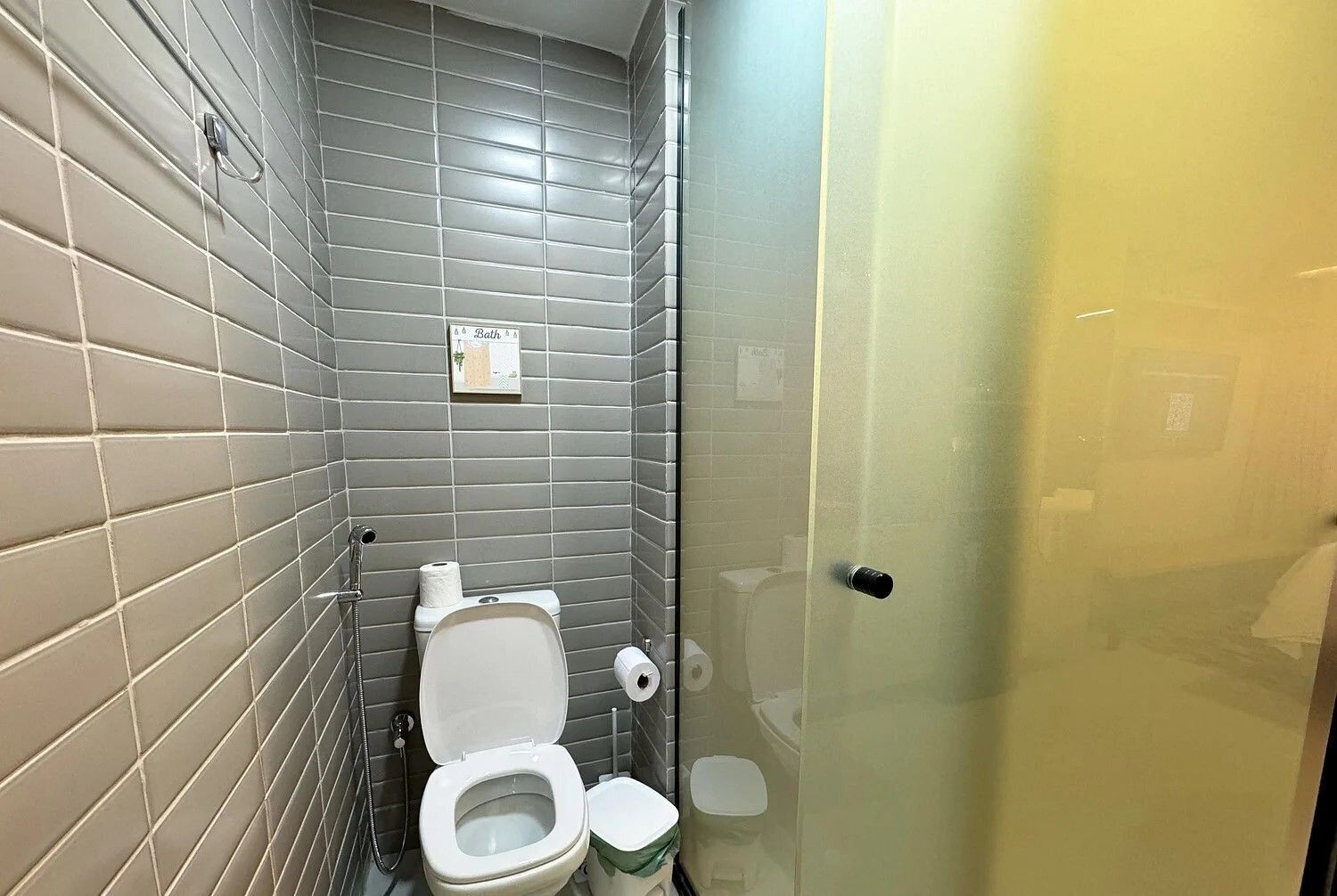 Un bagno piccolo con il water, una doccia e una porta in vetro.