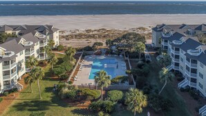 Ein Resort mit Swimmingpool, Blick auf den Strand und mehrstöckigen Gebäuden mit Balkonen.