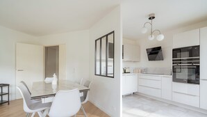 Eine moderne Küche mit weißen Schränken, einem Backofen und einer Mikrowelle.